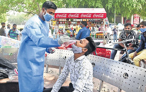 A health worker collects swab samples for coronavirus testing during a special camp at Connaught Place | PARVEEN NEGI
