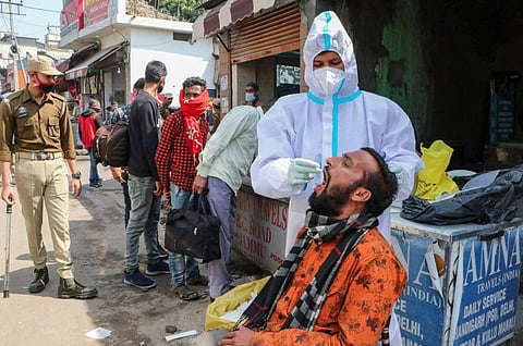 A health worker takes swab sample from a man for COVID-19 test. (Photo | PTI)