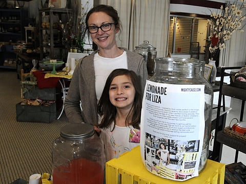 Elizabeth Scott and her 7-year-old daughter Liza Scott, who is running a lemonade stand to help fund her own brain surgery, are shown at the woman's bakery in Homewood, Ala., on March 2. (Photo | AP)