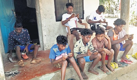 Children of Kadar Colony in Vazhachal playing games on mobile phones. The state government and NGOs have given phones to all students 