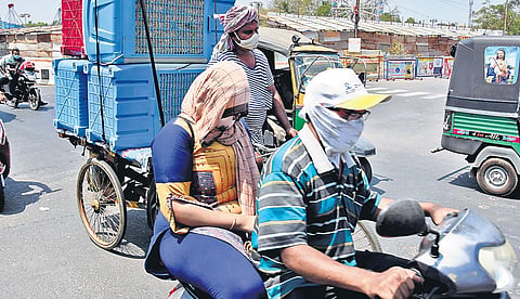 Commuters cover their faces to protect themselves from the scorching sun  on MG Road in Vijayawada on Wednesday | P Ravindra Babu