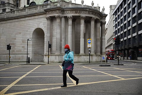 A woman walks past part of the Bank of England in the City of London financial district in London. (File Photo | AP)