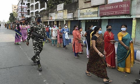 Voters stand in a queue to cast their vote at a polling station during fifth phase of State Assembly Election at Salt Lake, in Kolkata. (Photo | PTI)