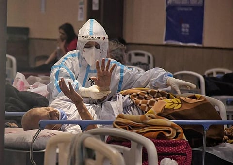 A health worker inspects COVID-19 patients undergoing treatment at Shehnai Banquet Hall, converted into an isolation centre amid surge in coronavirus cases, near LNJP Hospital in Delhi. (Photo | PTI)