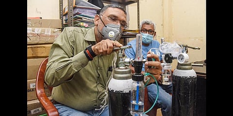 Social activist Gaurav Rai, popularly known as Oxygen Man' installs cylinders for the patients who are home-quarantined due to COVID-19, in Patna. (Photo | PTI)