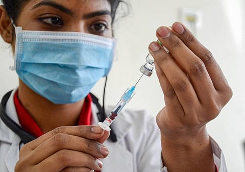 A medical worker prepares to inoculate person with a dose of COVID vaccine (Photo | PTI)