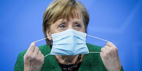 German Chancellor Angela Merkel removes her mask at the start of a press conference in the Chancellor's Office in Berlin. (File Photo| AP)