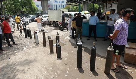 Family members wait to get their oxygen cylinders refilled as COVID cases rise in Delhi. (Photo | Shekhar Yadav, EPS)