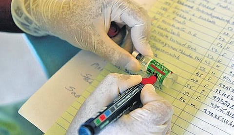 A health worker marks a vial during the vaccination drive at CV Raman Nagar Hospital  in Bengaluru on Friday  | Meghana Sastry