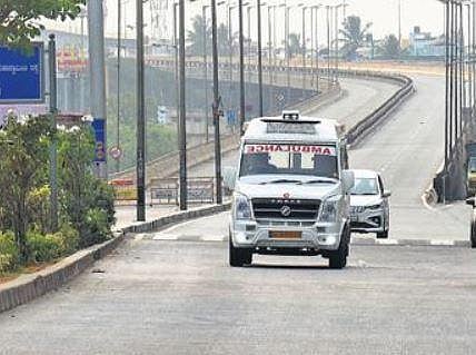 An ambulunce makes its way on a deserted road during the Corona curfew in Bengaluru on Thursday | VINOD KUMAR T