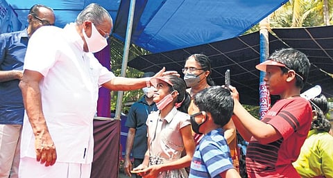 Chief Minister Pinarayi Vijayan shares a light moment with kids during his campaigning at Andallur in Dharmadom on Saturday | Express