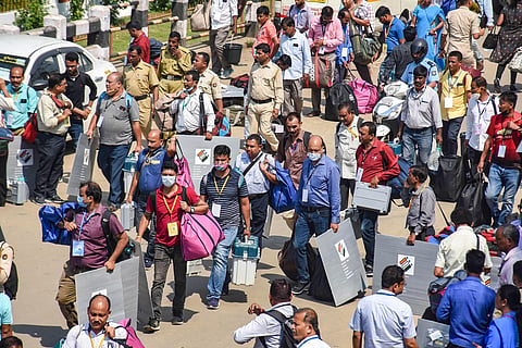 Officials carry EVMs and other materials as they leave for polling stations from a distribution centre on the eve of the final phase of Assam Assembly elections, in Guwahati on Monday. (Photo | PTI)