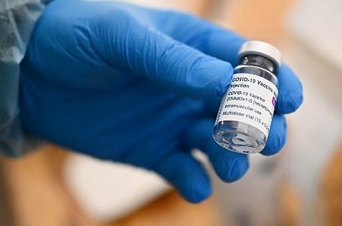 A doctor shows an empty vial of AstraZeneca vaccine against the coronavirus (Covid-19) are seen at a drive-in for vaccinations in Schwelm, western Germany. (Photo | AFP)