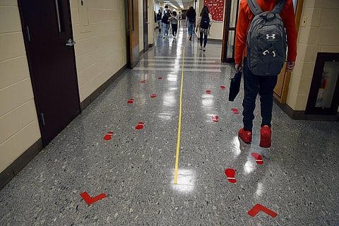 Students stay distanced and in separate lanes when passing between classes. (Photo | AP)