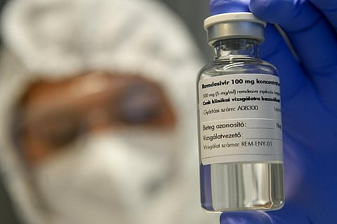 A bottle containing the drug Remdesivir is held by a health worker. (Photo | AP)