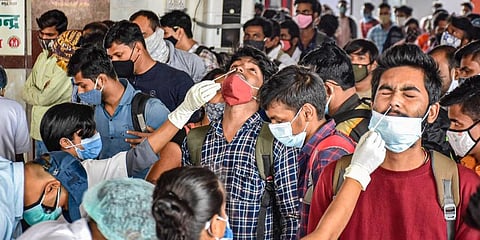 Health workers collect swab samples of the passengers arriving from Maharashtra at a COVID-19 testing counter at Patna railway station, Wednesday. (Photo | PTI)