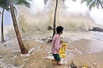 A youth placing sand bags to block sea intrusion is shocked after another huge wave crashes into the shore at Chellanam | file pic