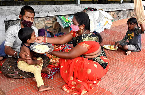 Mounika feeding a migrant man’s infant son in Tirupati city. (Photo | Madhav K, EPS)