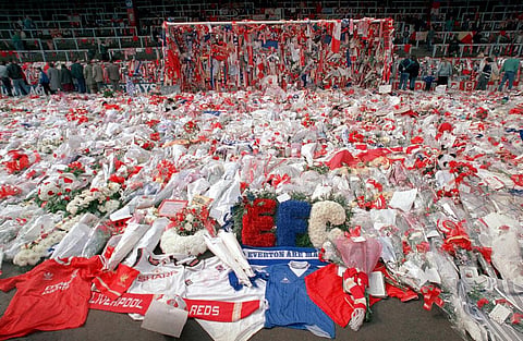 Liverpool soccer fans arrive at Anfield Stadium to pay their respects as flower tributes cover the 'Kop' end of the field, in Liverpool (Photo | AP)