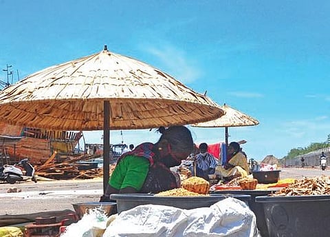 A fish seller tries to find comfort under the shade of an umbrella as day temperatures in Vizag city crosses 41 degree Celsius on Wednesday. (Photo | G Satyanarayana, EPS)