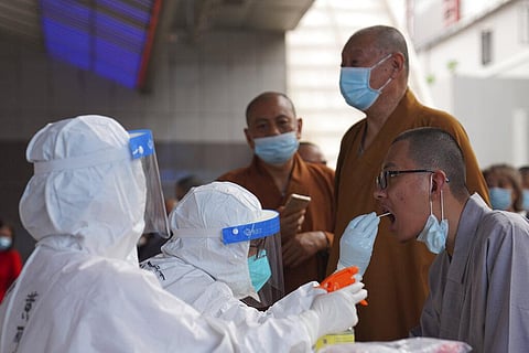 Monks get tested for the coronavirus in a district in Guangzhou in southern China's Guangdong province on Sunday, May 30, 2021. (Photo | AP_