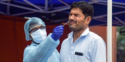A health worker in PPE takes swab samples of a man for RT PCR COVID-19 test. (File Photo | ANI)