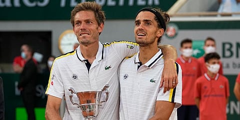 Nicolas Mahut (L) and Pierre-Hugues Herbert hold tier trophy after defeating Alexander Bublik and Andrey Golubev in their men's doubles final match of the French Open tournament. (Photo | AP)