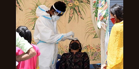 A health worker collects swab samples of a child in Mysuru on Sunday. (Photo | Udayshankar S, EPS)