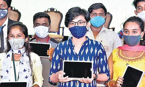 Students pose with the tablet PCs distributed by the State Government in Bengaluru on Wednesday  | nagaraja gadekal