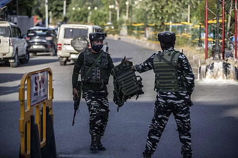 An Indian soldier passes a bulletproof vest to a colleague near the site of a grenade attack on a security force post in Srinagar. (Photo | AP)