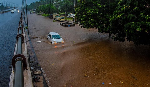 A car wades through the waterlogged road at NH-16 near Iskcon temple in Bhubaneswar. 
