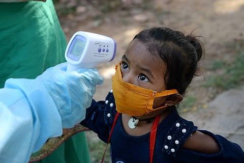 A medic screens a child of a migrant worker (File Photo | PTI)