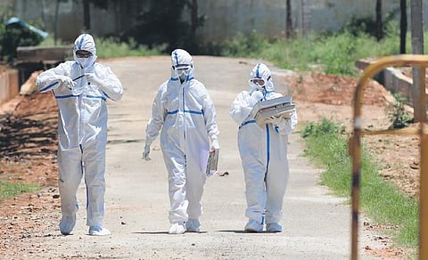 Health workers carry patients’ swabs from a Covid Care Centre at Doddabadagere in Harohalli, on the outskirts of Bengaluru on Wednesday | Ashishkrishna HP