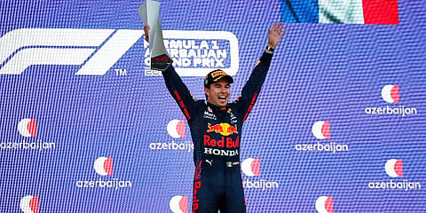 Red Bull driver Sergio Perez of Mexico jubilates with his trophy on the podium after winning the Formula One Grand Prix at the Baku Formula One city circuit. (Photo| AP)