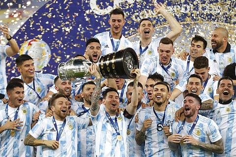 Argentina's Lionel Messi holds the Copa America trophy as he celebrates with teammates. 