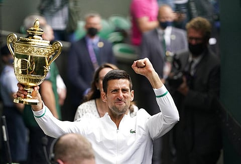 Serbia's Novak Djokovic holds the winner's trophy after his victory over Italy's Matteo Berrettini during the men’s singles final match on day thirteen of the Wimbledon. (Photo | AP)