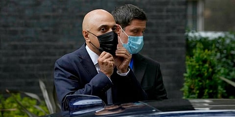 In this file photo from June 30, 2021, Britain's newly appointed Health Secretary Sajid Javid, left, puts on a face mask. (File photo | AP)