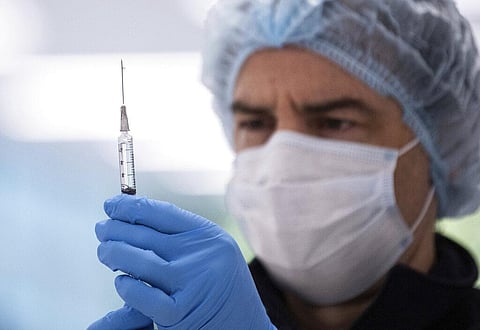 A technician prepares a Pfizer vaccine in the pharmacy area of a COVID-19 Vaccination Centre. (File photo | AP)