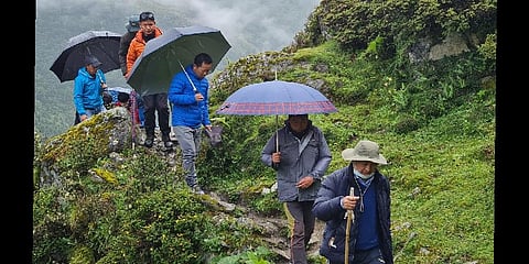 The team, led by Tawang District Magistrate Sang Phuntsok, trekking a mountain to reach the village, Luguthang. (Photo | Special arrangement)