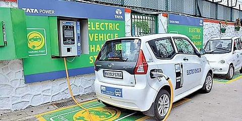 An electric vehicle replenishing charge at a charging station.
