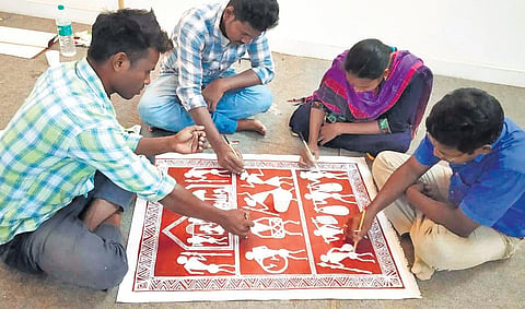 Savara artists painting to redecorate Odisha’s Bramhapur railway station. (Photo | Express)