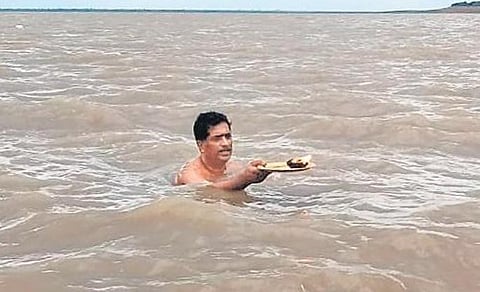 Priest Telkapalle Raghurama Sarma gives Jalaharathi to Sangameswara temple in Kurnool on Tuesday. (Photo | Express)