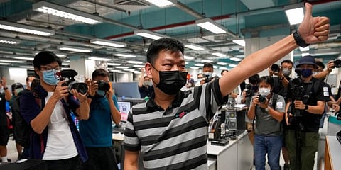 In this June 23, 2021, file photo, Lam Man-chung, center, executive editor-in-chief of Apple Daily, gestures at the headquarters before the newspaper stop publishing in Hong Kong. (File photo | AP)