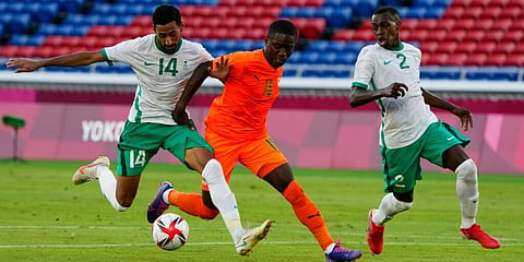 Saudi Arabia's Ali Alhassan, left battles for the ball with Ivory Coast's Max Gradel during a men's soccer match at the 2020 Summer Olympics, Thursday, July 22, 2021, in Yokohama, Japan. (Photo | AP)