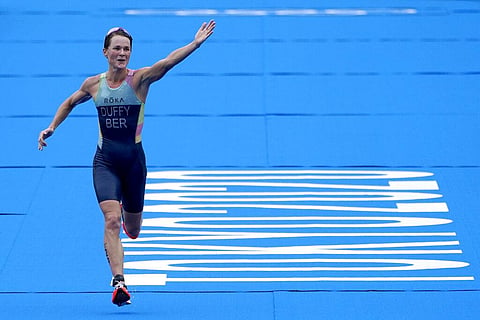 Flora Duffy, of Bermuda, celebrates while running to the finish line to win the women's individual triathlon at the 2020 Summer Olympics. (Photo | AP)