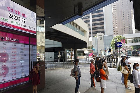 People stand in front of a bank's electronic board showing the Hong Kong share index at Hong Kong Stock Exchange in Hong Kong. 