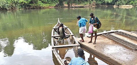 Tribal people of Kuchippara colony crossing the Kuttampuzha river in a  country boat. (Photo | Albin Mathew/EPS)