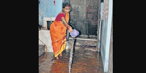 A woman drains out water from her house in Sutahat locality of Cuttack  on Tuesday | Rashmiranjan Mohapatra