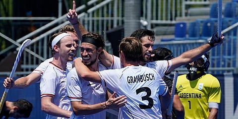 Germany players embrace Lukas Windfeder, right, after scoring against Argentina during a men's field hockey match at the 2020 Summer Olympics, in Tokyo, Japan. (Photo | AP)