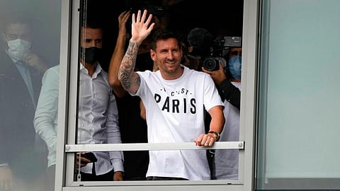 Lionel Messi waves after arriving at Le Bourget airport, north of Paris. 